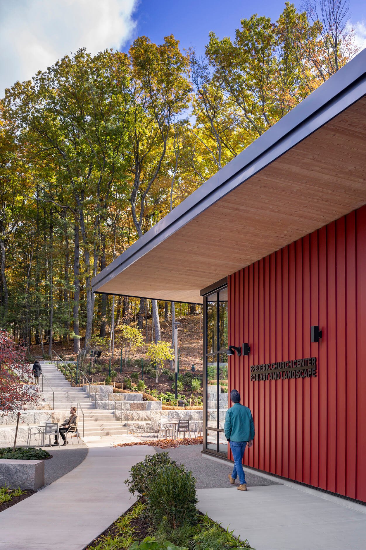 Exterior view of the The center is clad in red-stained, vertical wood siding on the Center